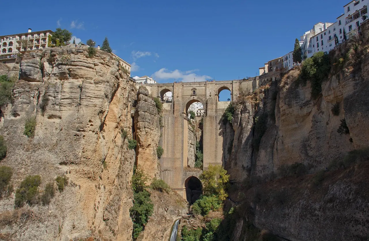 Puente Nuevo in Ronda — a daring 18th-century bridge spanning a vertiginous gorge, symbolizing courage and continuity among must-visit places in Spain. Puente Nuevo bridge spanning the El Tajo gorge in Ronda, with whitewashed buildings clinging to cliffs