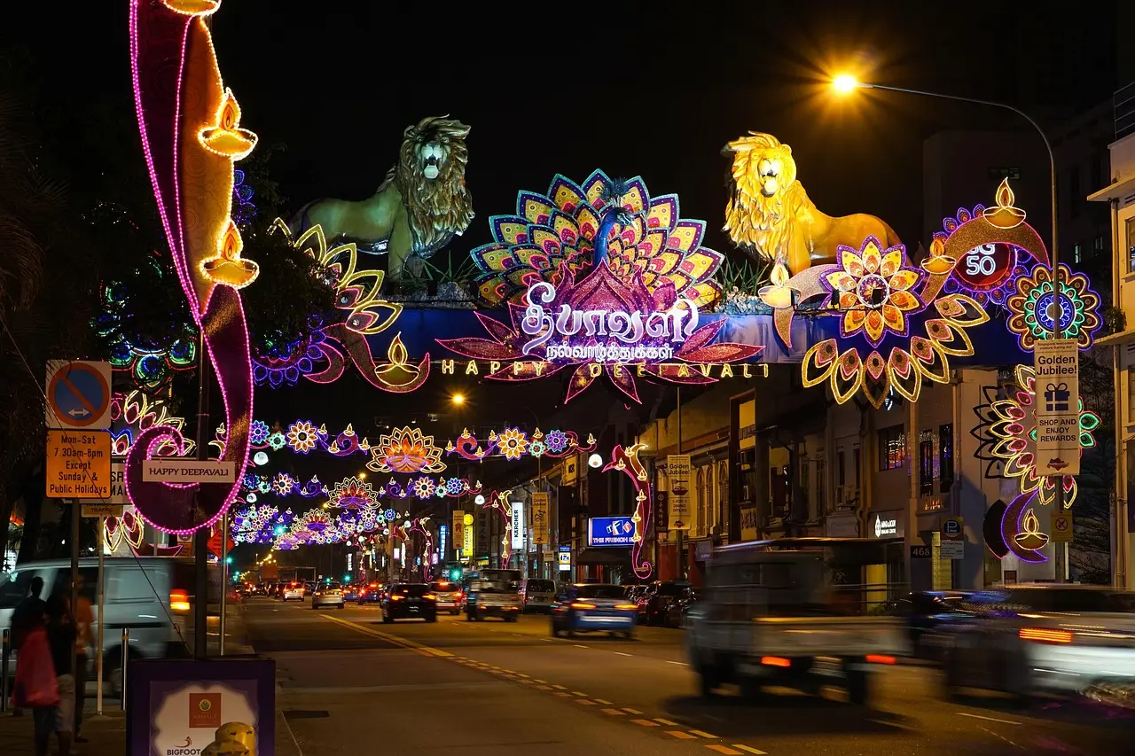 A lively Little India street during festive season—bursting with color, devotion, and tradition—proving why this is a vital in Singapore must-visit destination for culturally curious travelers. Little India street scene with decorated temple facade, flower garlands, and vibrant storefronts