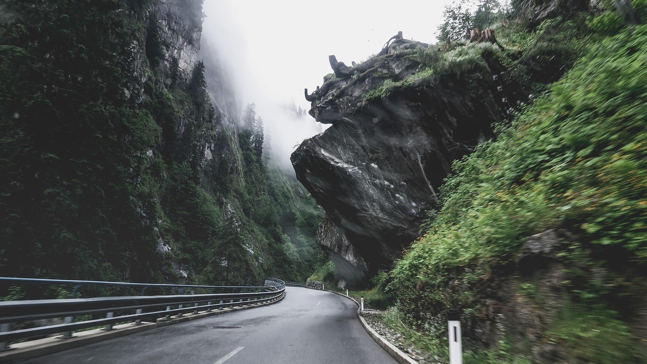 Aerial perspective of the serpentine Jebel Jais mountain road cutting through fog-draped limestone cliffs in Ras Al Khaimah Jebel Jais mountain road winding through misty cliffs with dramatic drop-offs