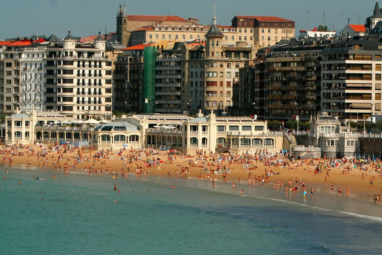 La Concha beach in San Sebastián — a postcard-perfect crescent of sand and sea, anchoring one of Spain’s most stylish and flavorful must-visit places in Spain. La Concha beach in San Sebastián with crescent bay, Belle Époque buildings, and sailboats