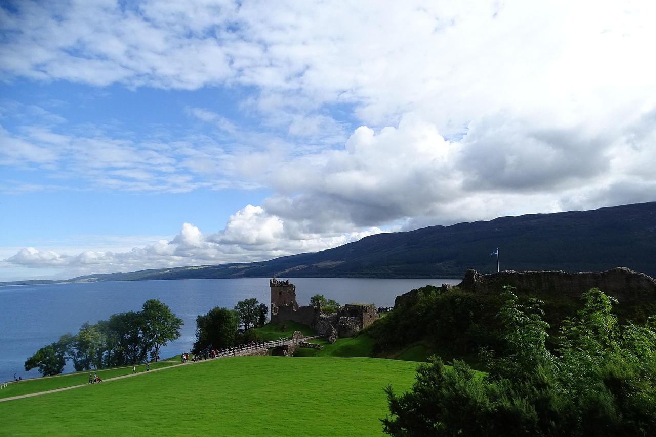 Atmospheric stillness of Loch Ness shrouded in Highland mist — an evocative, legendary entry among must-visit places in the UK Moody loch waters reflecting dark hills and mist under a grey sky in the Scottish Highlands