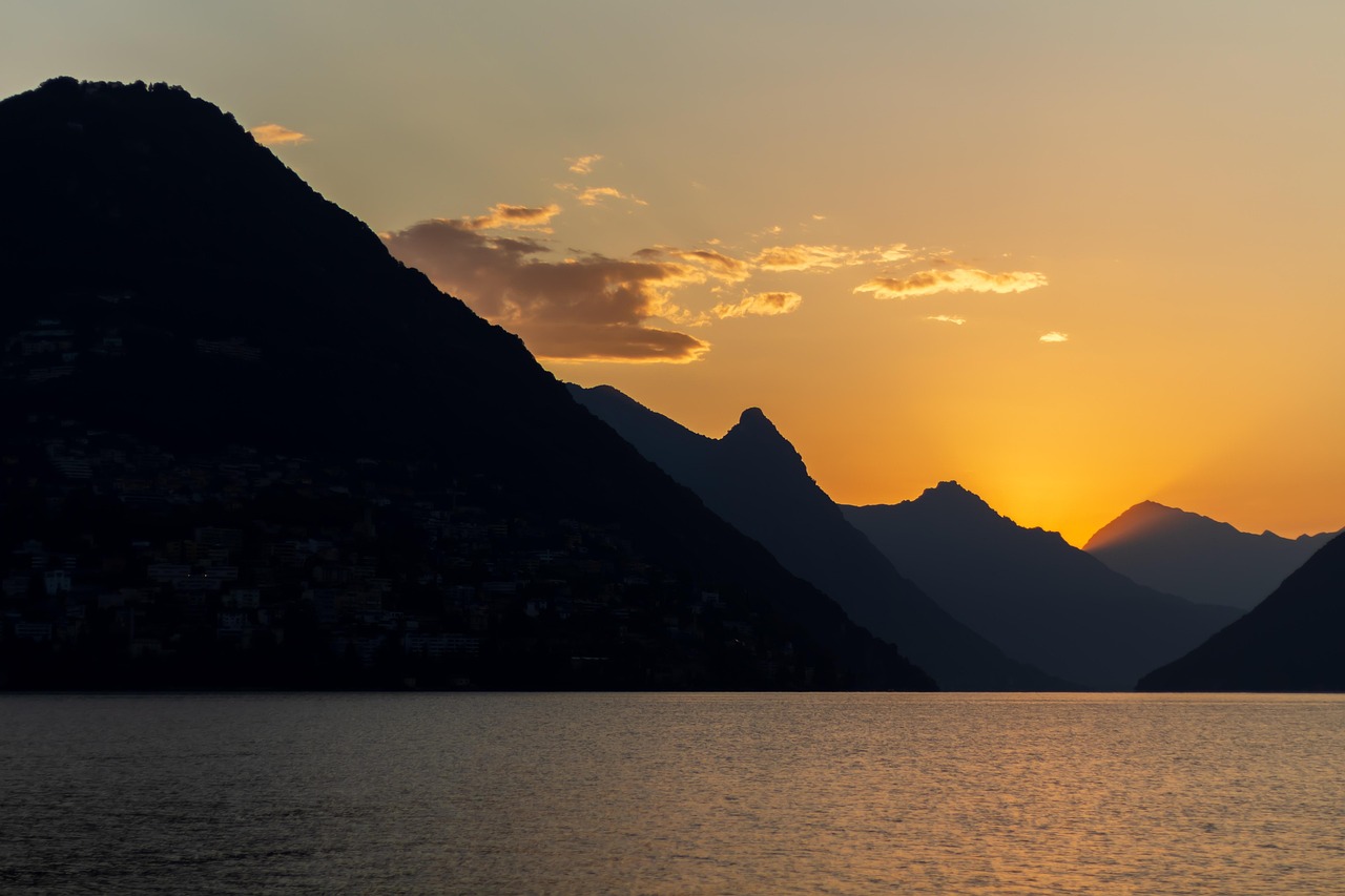 Serene alpine-style scenery in the Lake District — a top-tier destination among must-visit places in the UK Panoramic view of misty mountains and a reflective lake in the English Lake District