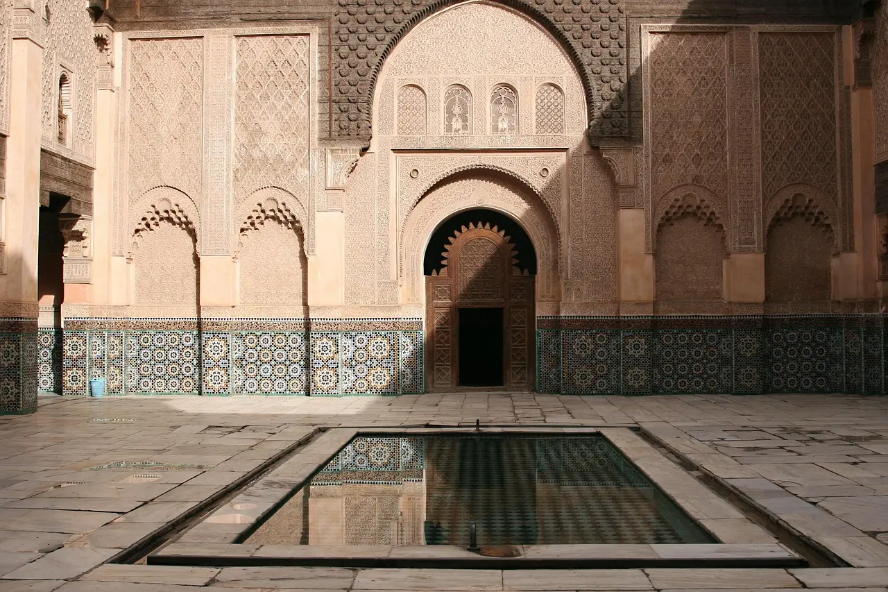 The iconic Court of the Lions at the Alhambra in Granada — a serene, symmetrical masterpiece representing the zenith of Nasrid design among must-visit places in Spain. Sunlit courtyard of the Alhambra's Court of the Lions with ornate arches and fountain