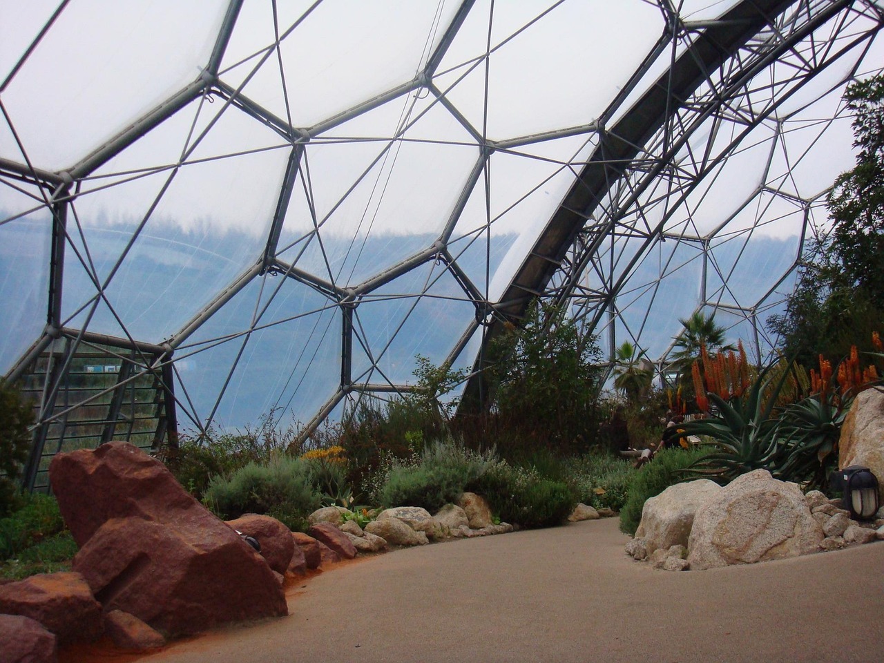 Futuristic domes of the Eden Project nestled in Cornwall’s verdant terrain — a visionary addition to must-visit places in the UK Geodesic domes of Eden Project rising from lush green Cornish landscape