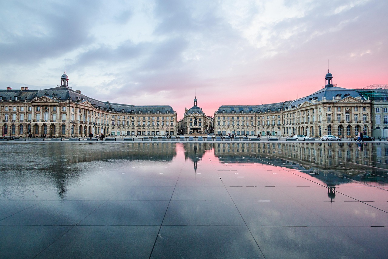 The shimmering reflection of Bordeaux’s golden limestone buildings in the expansive Miroir d’Eau — Europe’s largest reflecting pool Reflection of Bordeaux’s neoclassical architecture in the Miroir d'Eau water feature