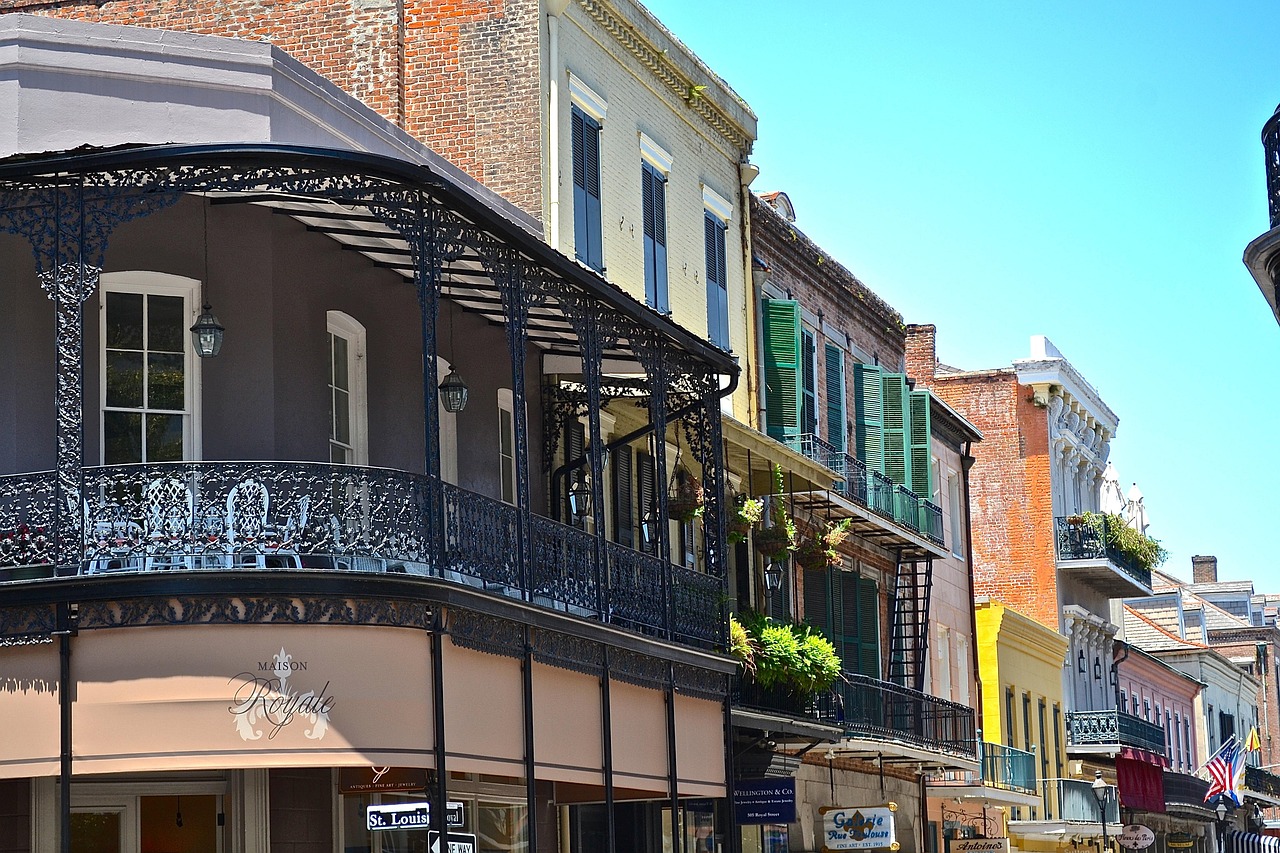 Pastel-hued buildings and intricate ironwork define the historic French Quarter — a vibrant highlight among must-visit places in the USA Colorful French Quarter building with wrought-iron balcony and hanging lanterns