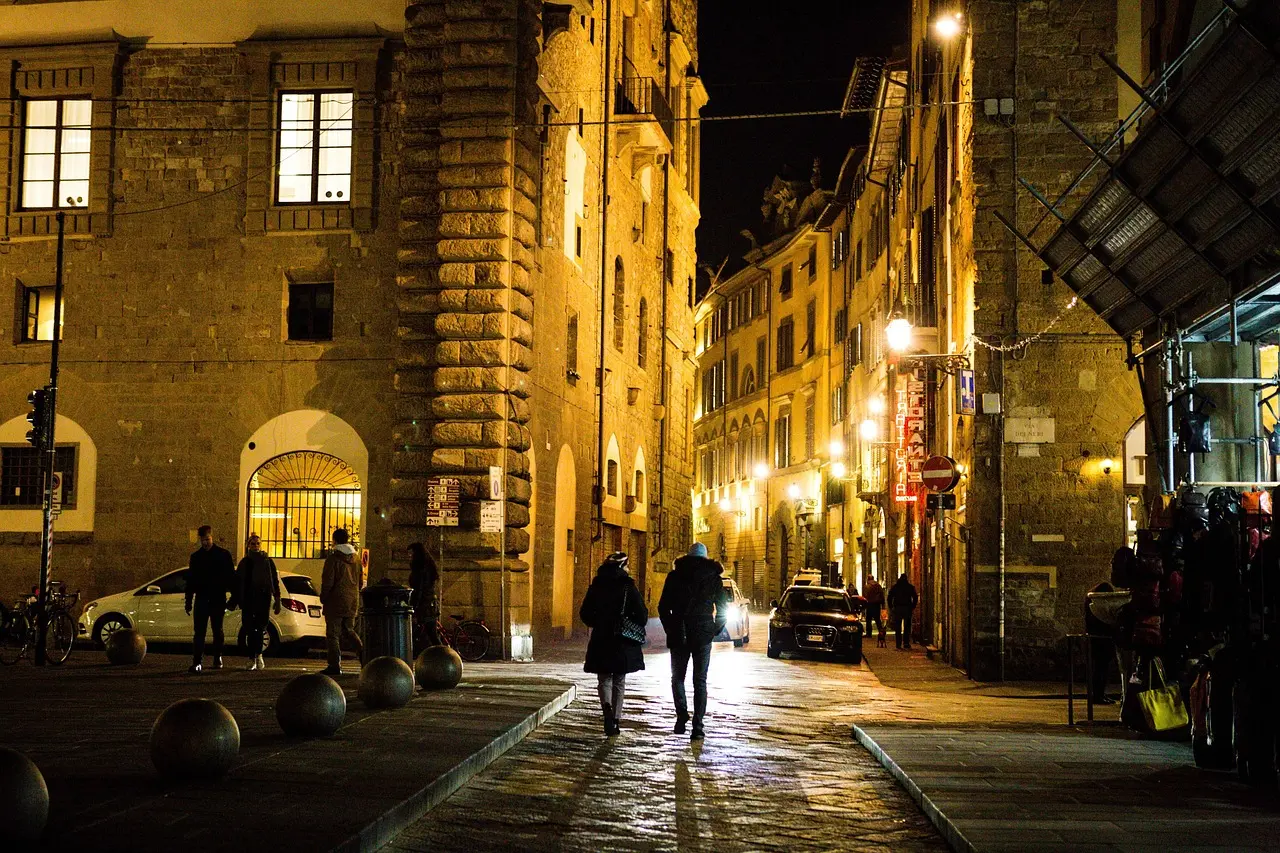 Pedestrian street in Florence historic center with tourists walking past boutique shops