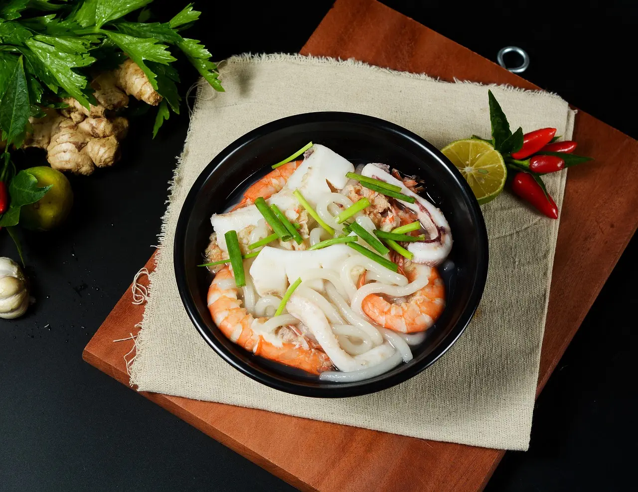 Hanoi’s food travel destinations embody balance, tradition, and the quiet power of authentic local cuisine Steaming bowl of Hanoi-style pho with basil, lime, and chili on a rustic wooden table