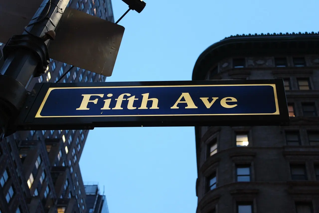 Classic New York shopping scene showing how savvy travelers optimize shopping consumption despite absence of formal duty-free policies Fifth Avenue in Manhattan with iconic storefronts, holiday decorations, and shoppers holding shopping bags