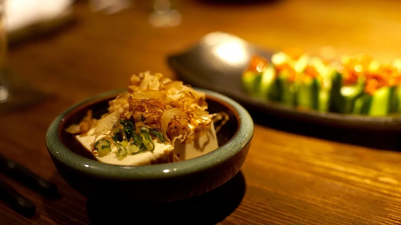 Authentic kaiseki dining experience in Kyoto featuring spring bamboo shoots, grilled ayu, and edible cherry blossoms on handcrafted pottery Elegant kaiseki course served on hand-painted ceramic plates with seasonal flowers
