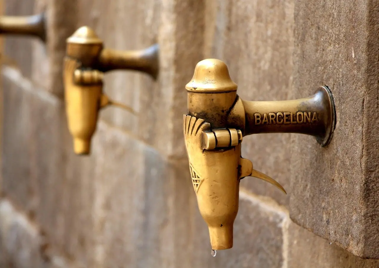 Public drinking fountain (nasoni) in Florence with a person refilling a water bottle