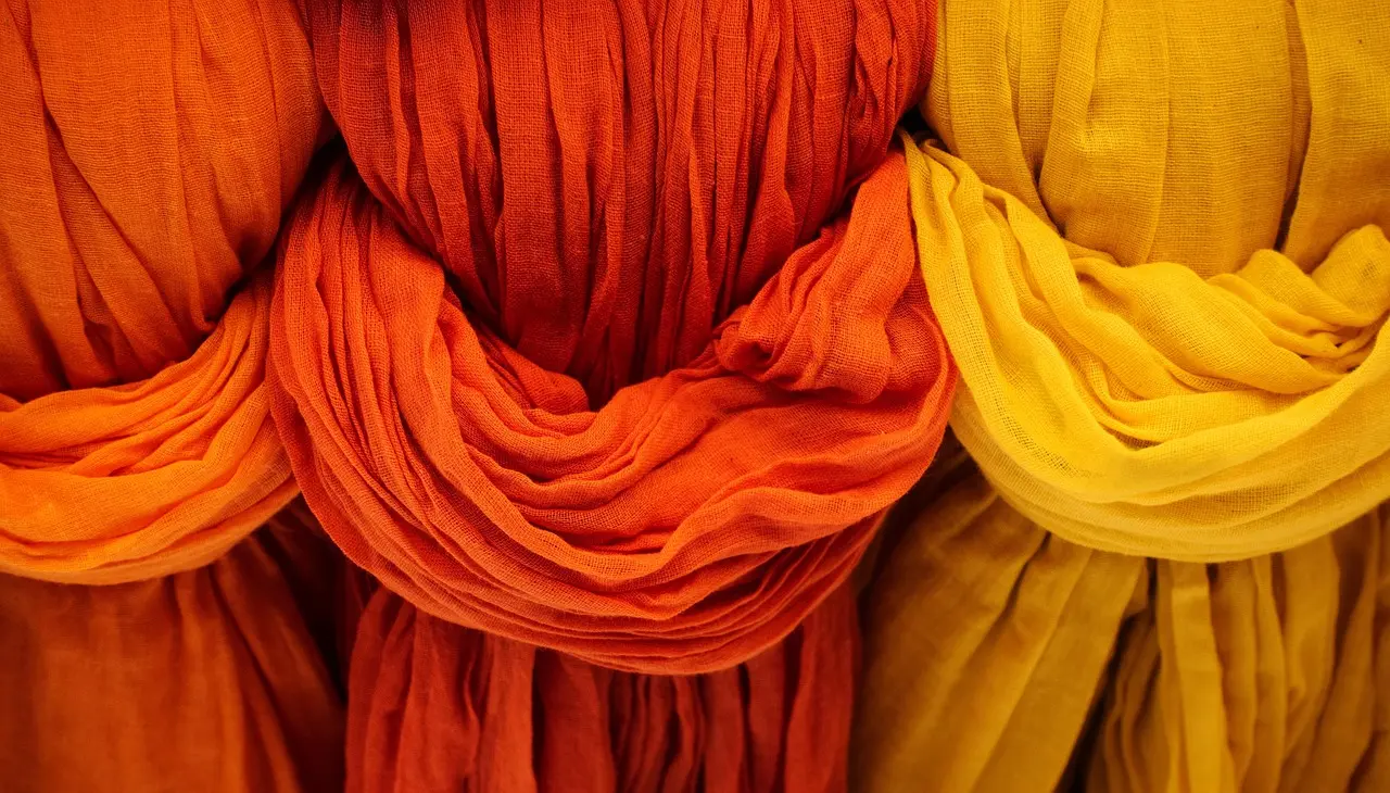 Natural dye workshop in Lima using ancestral cochineal techniques for Andean wool textiles Peruvian artisan grinding cochineal insects with a stone mortar to produce vivid red natural dye for alpaca wool