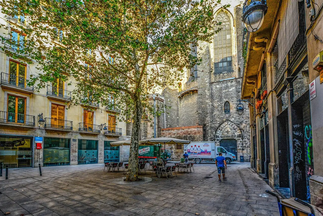 Narrow cobblestone street in Barcelona's Gothic Quarter with arched doorways and hanging laundry