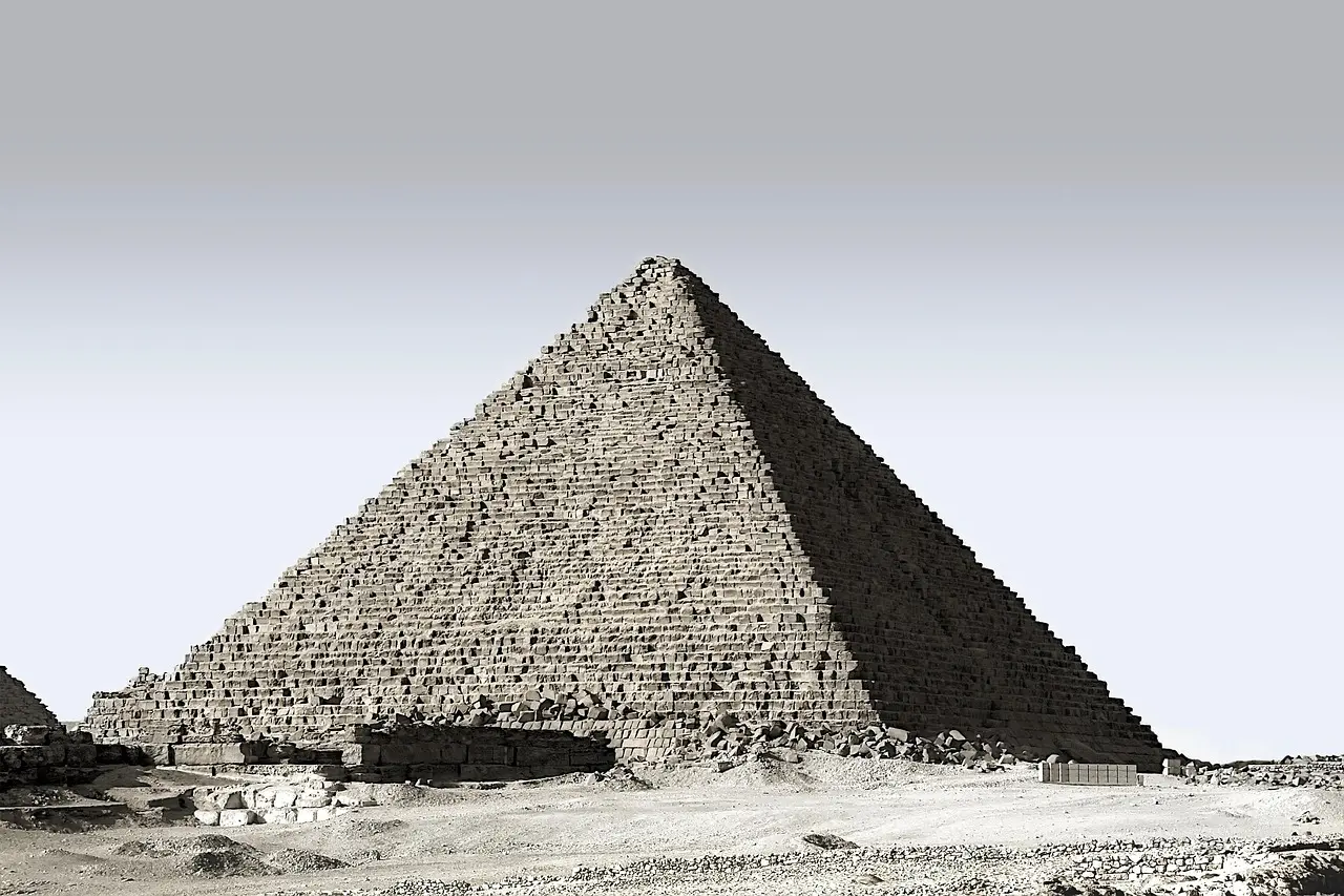 Sunset bathes the Great Pyramid and Sphinx in warm light — a quintessential scene for anyone planning to visit ancient landmarks in Egypt. Golden-hour light illuminating the Great Pyramid of Giza with the Sphinx in foreground