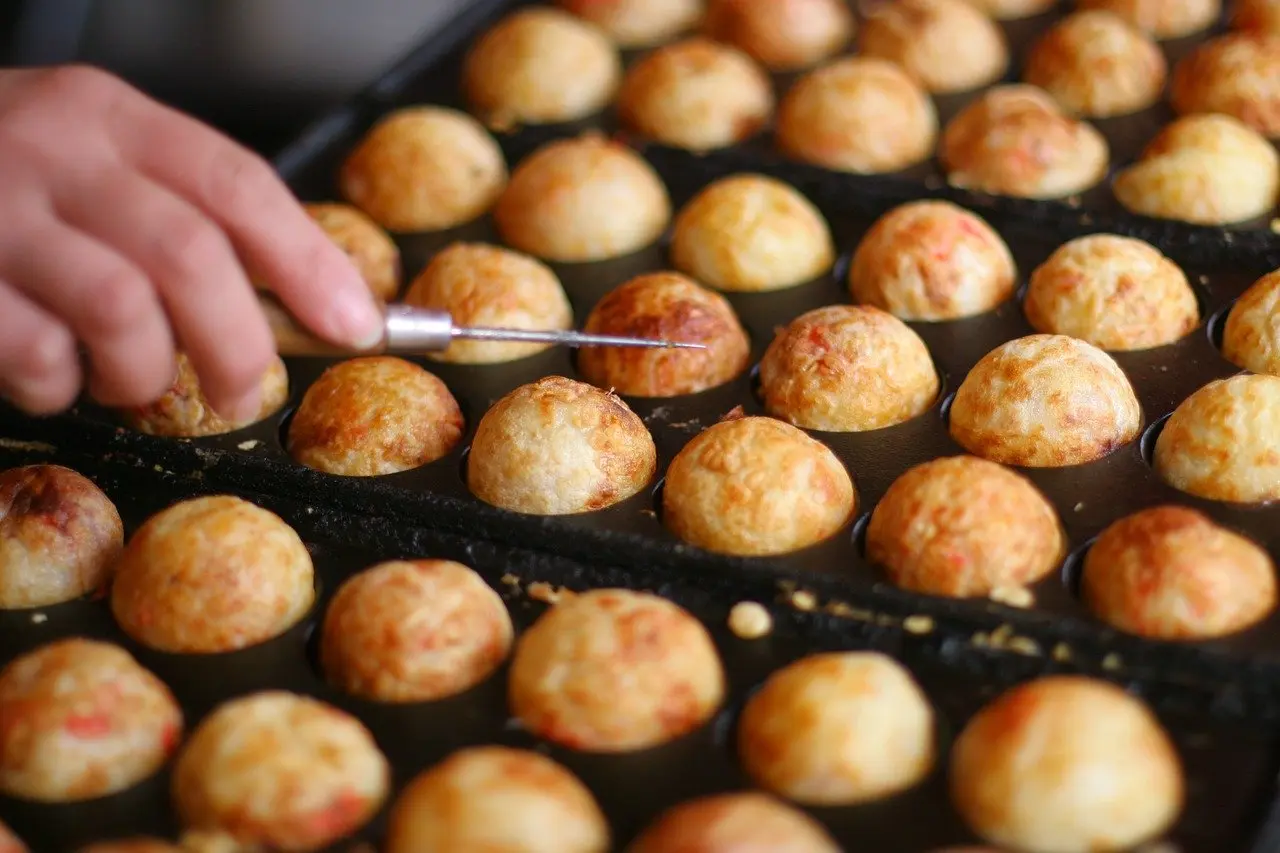 These five underrated food travel destinations offer exceptional authenticity and diverse expressions of local cuisine Collage of five regional dishes: Georgian khinkali, Brazilian acarajé, Tasmanian truffle pasta, Sichuan dan dan noodles, Moroccan goat cheese