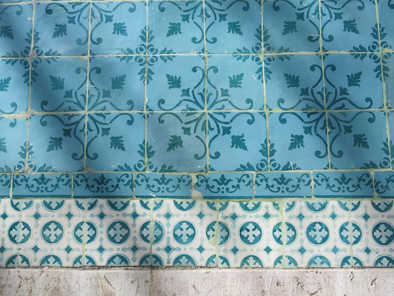 Azulejo painting workshop in Lisbon, teaching traditional Portuguese ceramic decoration techniques Student painting intricate blue-and-white azulejo tile design in a sunlit Lisbon studio with historic ceramic samples on display
