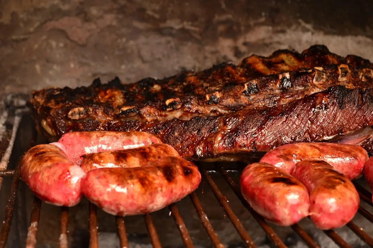 Traditional Argentine asado cooking class in Palermo, featuring grass-fed beef ribs, morcilla, and house-made chimichurri Smoky outdoor asado grill with skewered meats and chimichurri in terracotta bowl