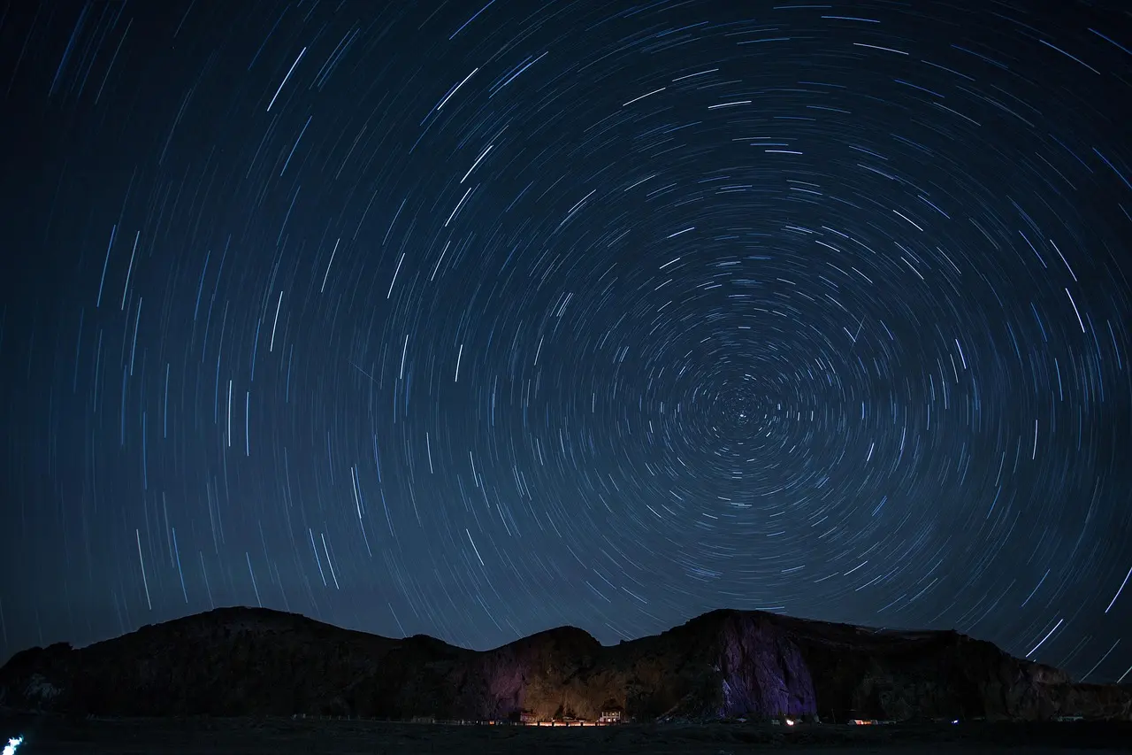 An intimate, emotionally resonant nighttime ritual — part of a broader strategy to deliver memorable, locally grounded experience resort entertainment and services Guests seated on woven mats around a bonfire under starry sky, listening to a storyteller