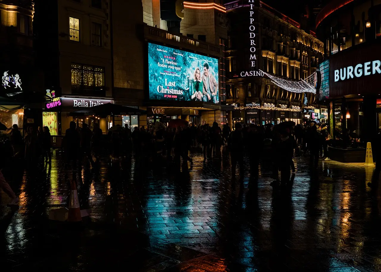 Noisy, neon-lit street near Leicester Square with touts and crowded bars
