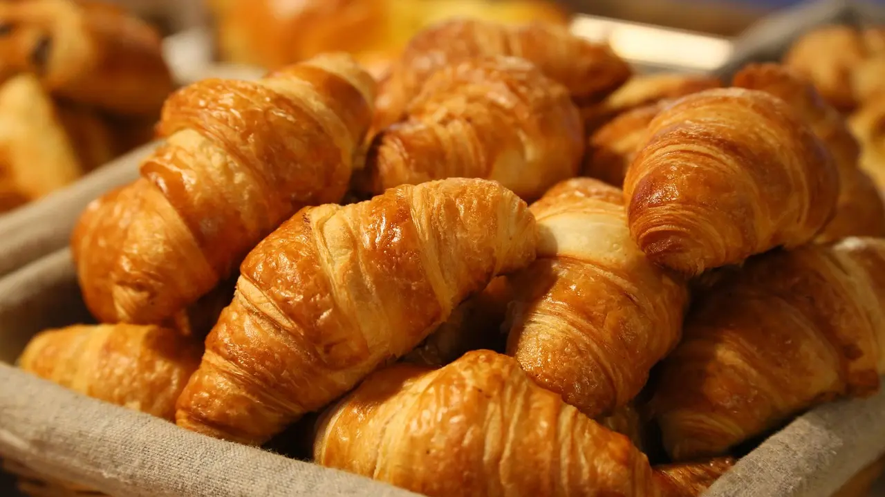 Close-up of fresh maritozzo pastry with whipped cream oozing out, on rustic wooden table