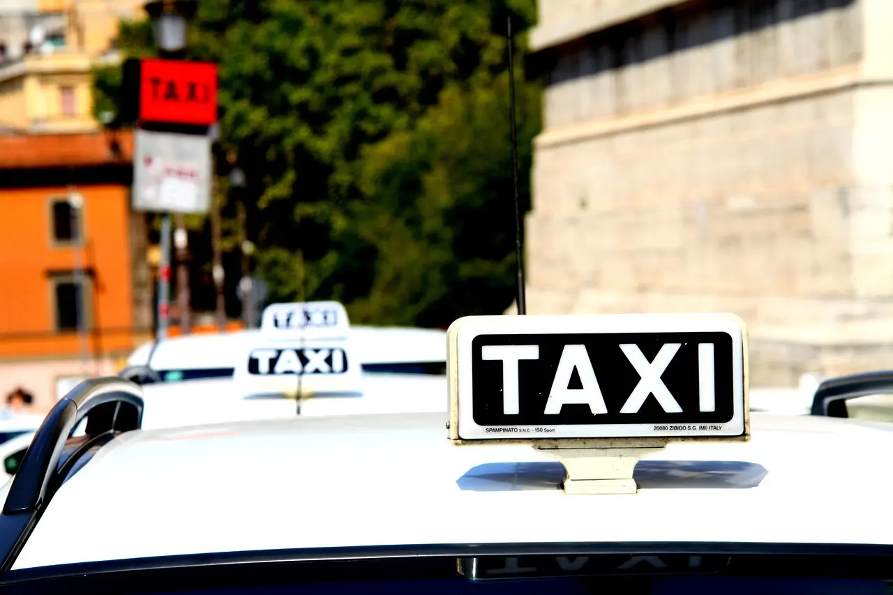 Official white Rome taxi with meter running near Termini Station