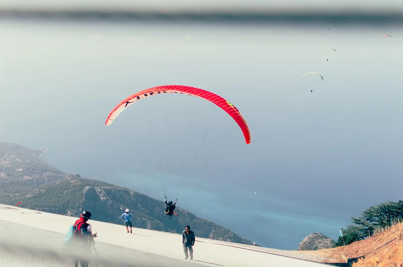 Paraglider soaring above Ölüdeniz beach with turquoise lagoon below