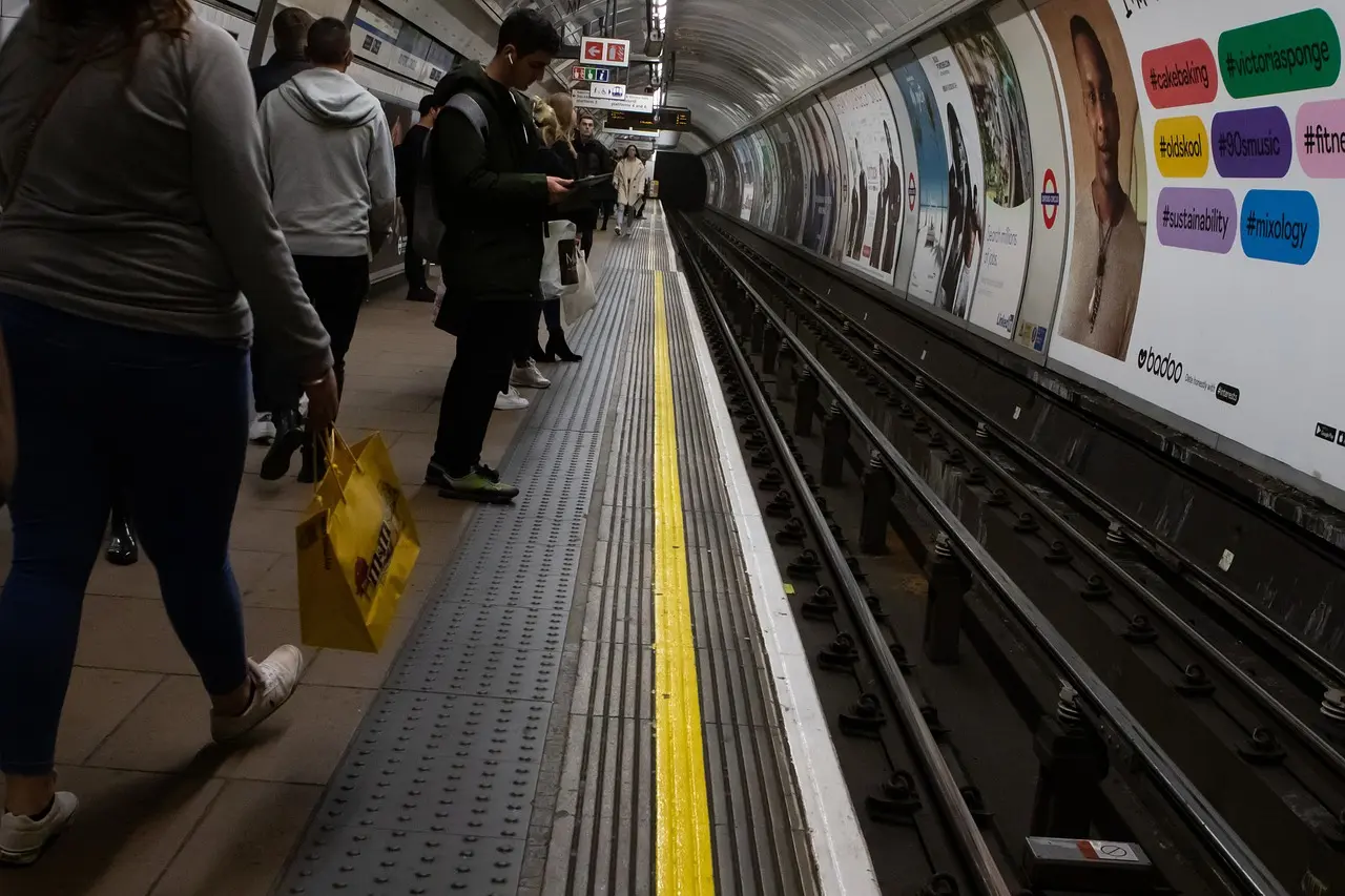 Crowded London Tube carriage with warning sign about pickpockets