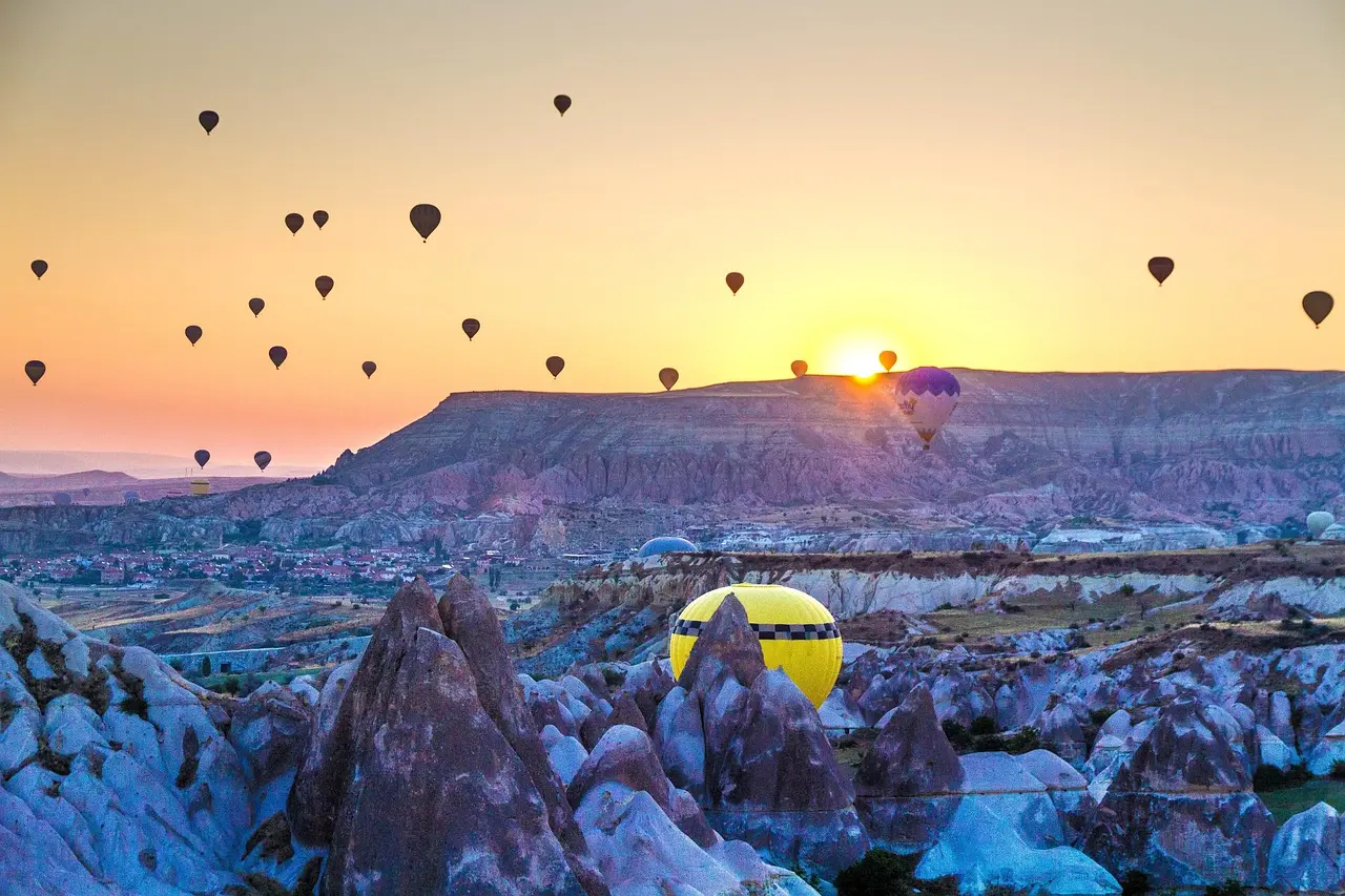 Hot air balloons floating above Cappadocia's fairy chimneys at sunrise