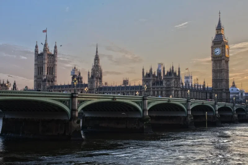 Aerial view of central London with Big Ben, Thames River, and red double-decker buses