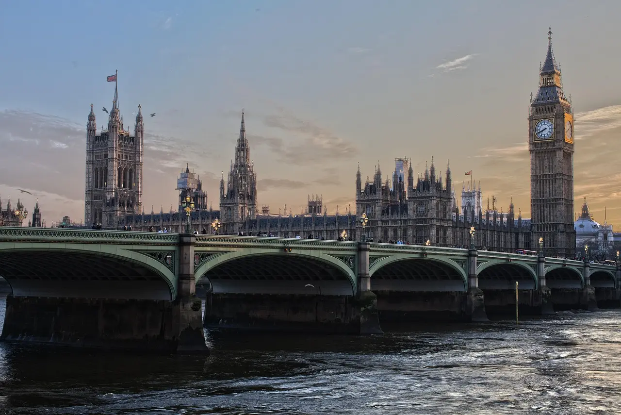 Aerial view of central London with Big Ben, Thames River, and red double-decker buses
