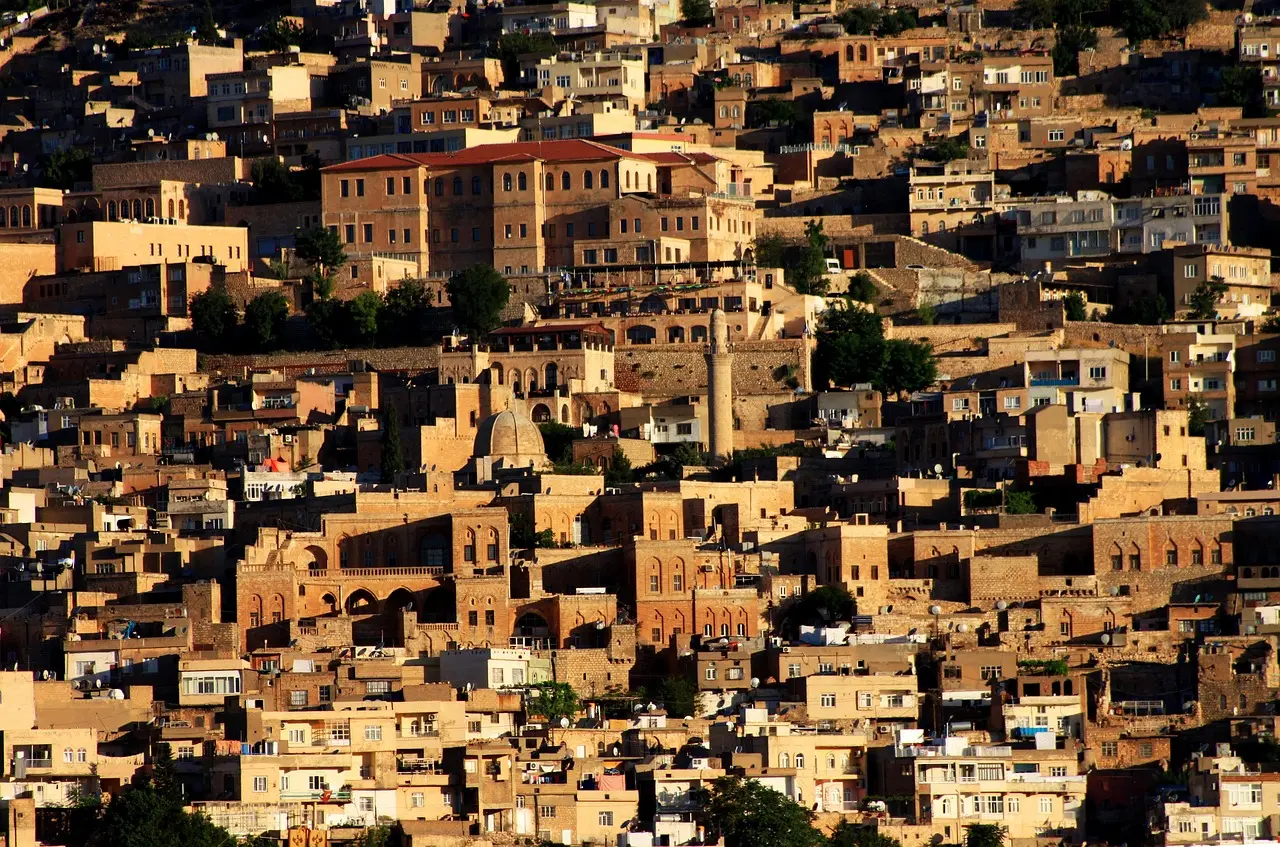 Honey-colored stone buildings of Mardin under clear blue sky