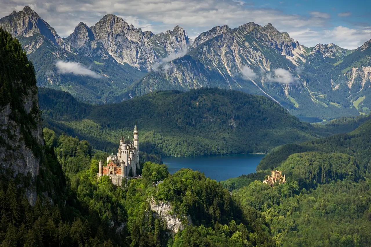 Neuschwanstein Castle surrounded by green hills and blue sky