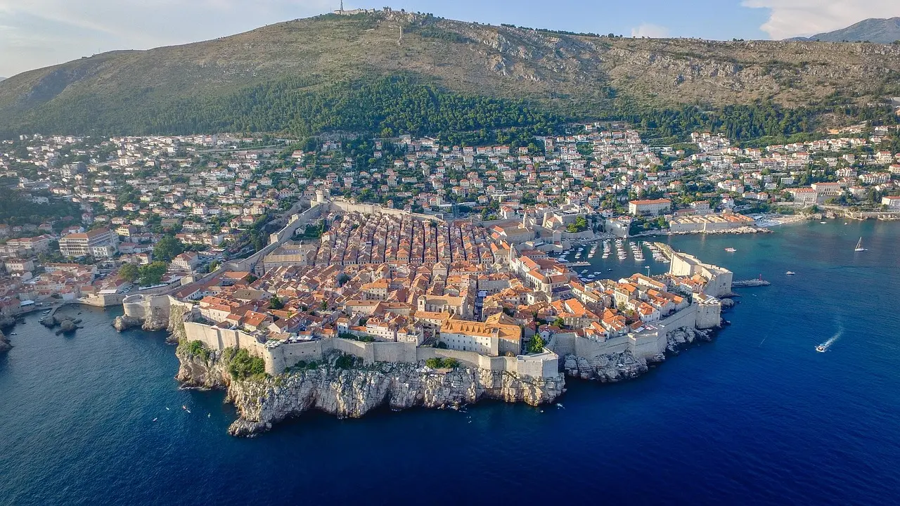 Dubrovnik city walls at sunrise with orange rooftops and sea
